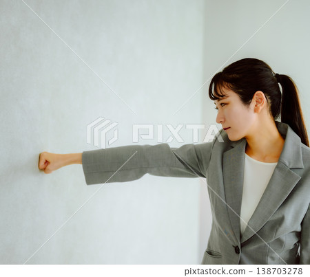 Female employee banging her fist against the wall 138703278