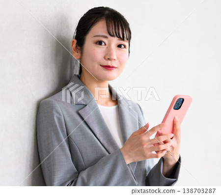 Business woman with a smartphone in the office Business woman with a smartphone in the office 138703287
