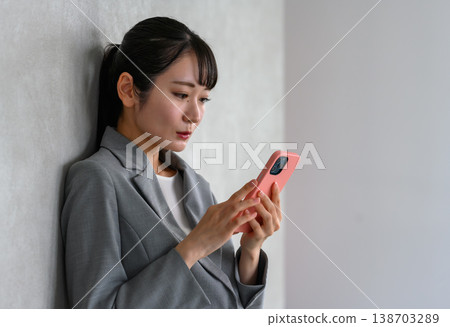 Business woman operating a smartphone Business woman operating a smartphone 138703289