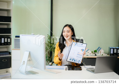 Asian businesswoman working with working notepad, tablet and laptop documents talking on the smartphone, tablet Asian businesswoman working with working notepad, tablet and laptop documents talking on the smartphone, tablet 138703714