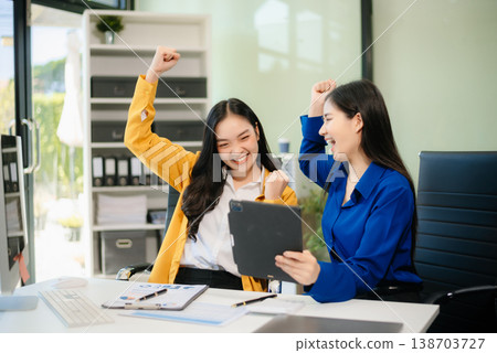 Business professionals collaborating in a modern office, planning and discussing ideas with laptops. Business professionals collaborating in a modern office, planning and discussing ideas with laptops. 138703727