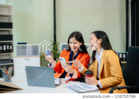 Business professionals collaborating in a modern office, planning and discussing ideas with laptops. Business professionals collaborating in a modern office, planning and discussing ideas with laptops. 138703766