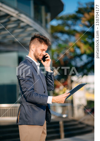 Successful Businessman in suit using tablet outdoors. Perfect for corporate, technology, and professional themes Successful Businessman in suit using tablet outdoors. Perfect for corporate, technology, and professional themes 138704177