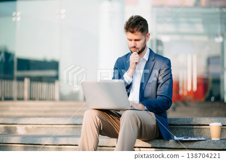 Successful Businessman in suit using tablet outdoors. Perfect for corporate, technology, and professional themes Successful Businessman in suit using tablet outdoors. Perfect for corporate, technology, and professional themes 138704221