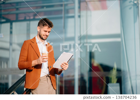 Successful Businessman in suit using tablet outdoors. Perfect for corporate, technology, and professional themes Successful Businessman in suit using tablet outdoors. Perfect for corporate, technology, and professional themes 138704236