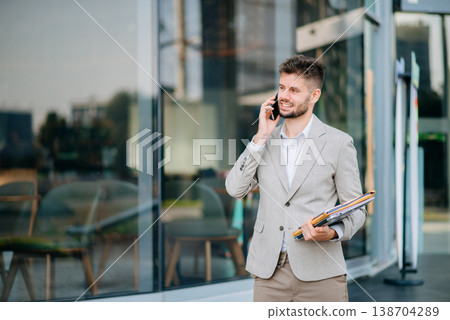 Successful Businessman in suit using tablet outdoors. Perfect for corporate, technology, and professional themes Successful Businessman in suit using tablet outdoors. Perfect for corporate, technology, and professional themes 138704289