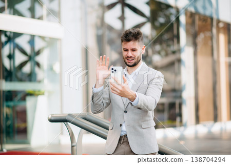 Successful Businessman in suit using tablet outdoors. Perfect for corporate, technology, and professional themes 138704294