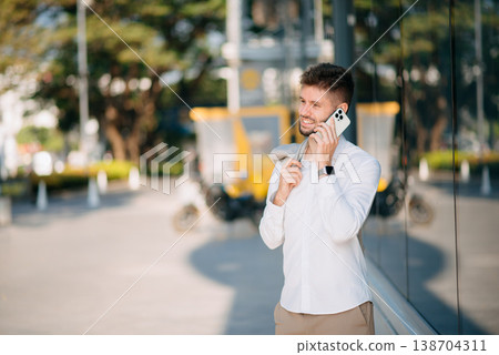 Businessman standing outdoors and using digital tablet. Perfect for corporate, technology, and professional themes 138704311