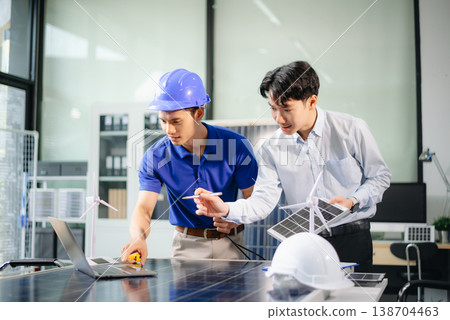 Two Asian engineers collaborate on solar and wind energy, driving clean innovation and sustainability. Two Asian engineers collaborate on solar and wind energy, driving clean innovation and sustainability. 138704463