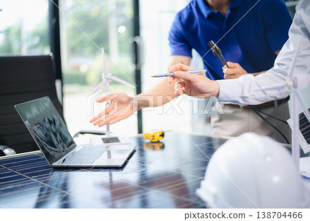 Engineers discuss solar panels and turbines in office, working on clean energy design, sustainable power, Engineers discuss solar panels and turbines in office, working on clean energy design, sustainable power, 138704466