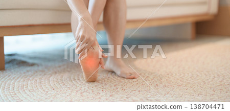 woman having barefoot pain at home. Foot ache due to Plantar fasciitis and waking longtime. Health and medical concept 138704471