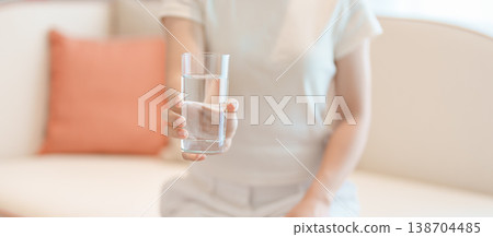 Healthy woman hold glass of clean mineral water glass on sofa at home, female drink pure water for hydration and wellness, fresh skin care, daily routine water intake, Refreshment and lifestyle Healthy woman hold glass of clean mineral water glass on sofa at home, female drink pure water for hydration and wellness, fresh skin care, daily routine water intake, Refreshment and lifestyle 138704485