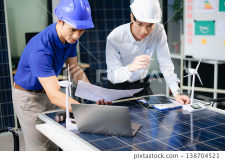 Two Asian engineers collaborate on solar and wind energy, driving clean innovation and sustainability. Two Asian engineers collaborate on solar and wind energy, driving clean innovation and sustainability. 138704521