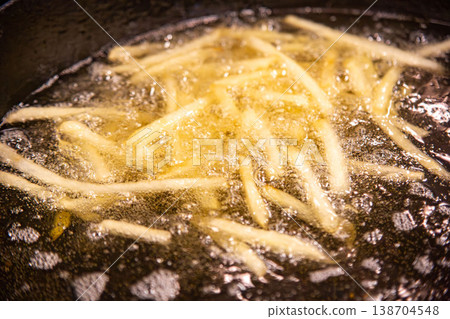 Close-up of bubbles in oil while frying french fries (hot oil during cooking) 138704548