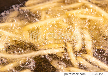 Close-up of bubbles in oil while frying french fries (hot oil during cooking) 138704549