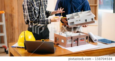 Architects and engineers collaborate on a building model, designing, planning, and measuring with teamwork, precision Architects and engineers collaborate on a building model, designing, planning, and measuring with teamwork, precision 138704584