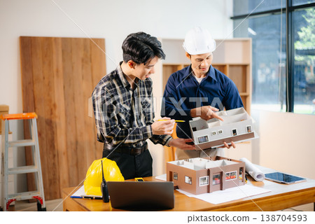 Architects and engineers collaborate on a building model, designing, planning, and measuring with teamwork, precision Architects and engineers collaborate on a building model, designing, planning, and measuring with teamwork, precision 138704593