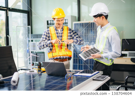 Engineers discuss solar panels and turbines in office, working on clean energy design, sustainable power Engineers discuss solar panels and turbines in office, working on clean energy design, sustainable power 138704604