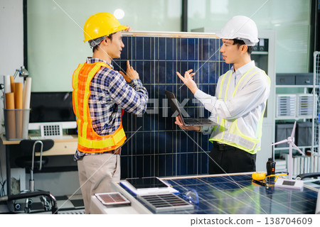 Engineers discuss solar panels and turbines in office, working on clean energy design, sustainable power 138704609