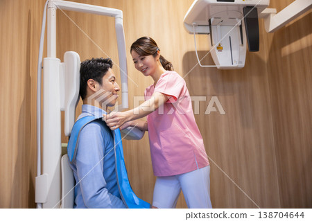Dental image: A man receiving a panoramic X-ray. Dental image: A man receiving a panoramic X-ray. 138704644