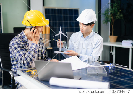 Business people having consultation about wind energy at company office. Business team discussing about windmill and alternative green energy. Business people having consultation about wind energy at company office. Business team discussing about windmill and alternative green energy. 138704667
