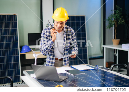 Two Asian engineers collaborate on a solar and wind energy project, discussing innovation 138704705