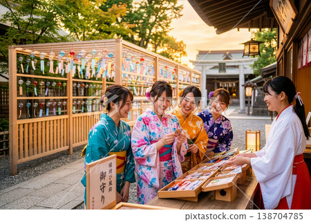 A group of Asian women in yukata (summer kimonos) choosing amulets at a shrine. A group of Asian women in yukata (summer kimonos) choosing amulets at a shrine. 138704785