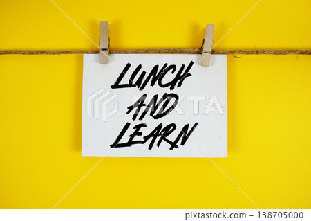 Lunch And Learn text written on paper card with rope and wooden clip hanging 138705000