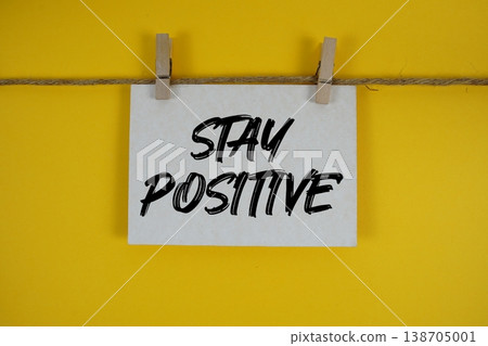 Stay Positive text written on paper card with rope and wooden clip hanging Stay Positive text written on paper card with rope and wooden clip hanging 138705001