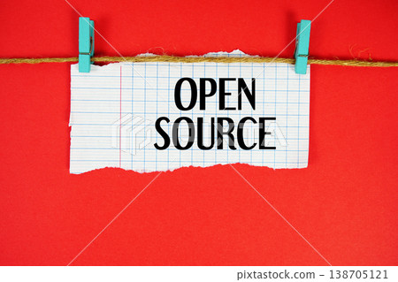 Open Source text written on rip paper with wooden clip on red background 138705121