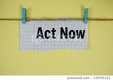 Act Now text written on rip paper with wooden clip on yellow background Act Now text written on rip paper with wooden clip on yellow background 138705122