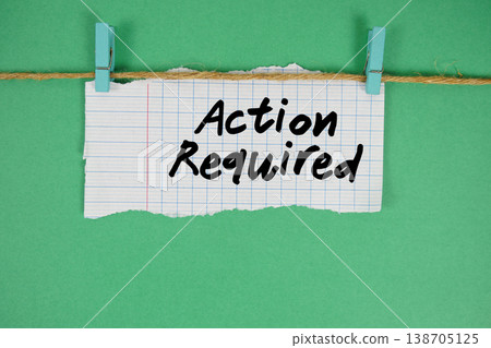 Action Required text written on rip paper with wooden clip on green background 138705125