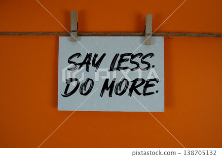 Say Less Do More text written on paper card with rope and wooden clip hanging Say Less Do More text written on paper card with rope and wooden clip hanging 138705132