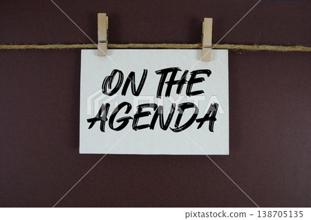 On the Agenda text written on paper card with rope and wooden clip hanging On the Agenda text written on paper card with rope and wooden clip hanging 138705135