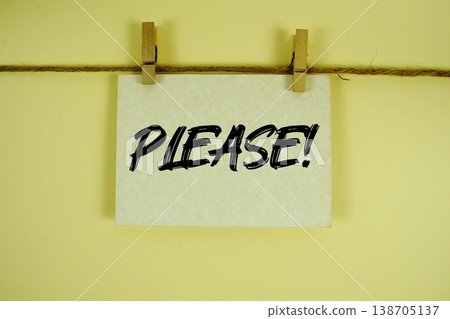 Please! text written on paper card with rope and wooden clip hanging 138705137