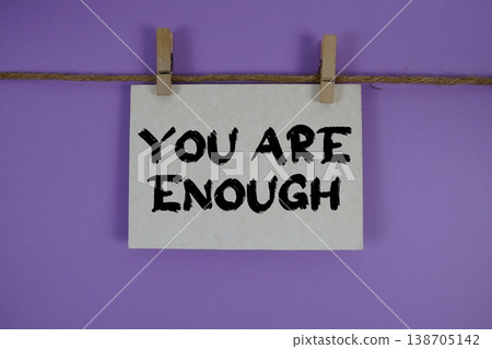 You Are Enough text written on paper card with rope and wooden clip hanging You Are Enough text written on paper card with rope and wooden clip hanging 138705142