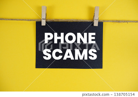 Phone Scams text written on paper card with rope and wooden clip hanging Phone Scams text written on paper card with rope and wooden clip hanging 138705154