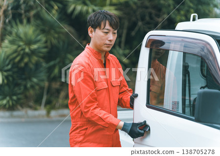 一輛輕型卡車和一個穿著工作服的男人 一輛輕型卡車和一個穿著工作服的男人 138705278