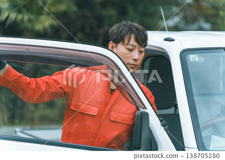 一輛輕型卡車和一個穿著工作服的男人 一輛輕型卡車和一個穿著工作服的男人 138705280
