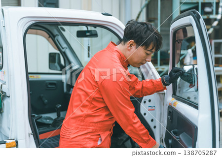 一輛輕型卡車和一個穿著工作服的男人 138705287