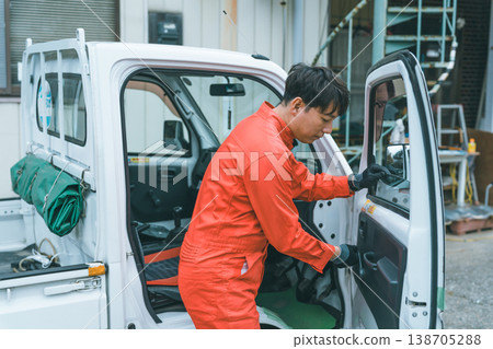 A light truck and a man in overalls A light truck and a man in overalls 138705288