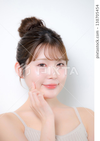 觸摸一位年輕女性的臉頰，她擁有晶瑩剔透、容光煥發的肌膚，水潤飽滿，如嬰兒般富有彈性。 138705454