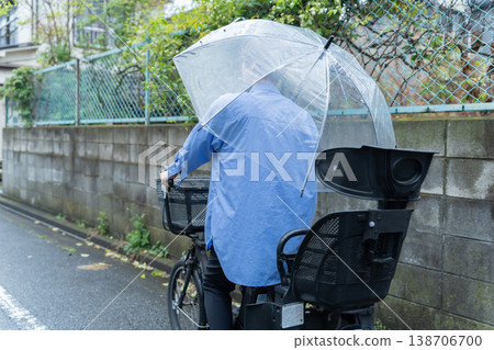 Woman riding a bicycle while holding an umbrella - Traffic violation 138706700