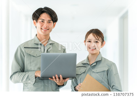 Male and female staff members having a meeting at a factory, warehouse, or logistics center. Male and female staff members having a meeting at a factory, warehouse, or logistics center. 138707375