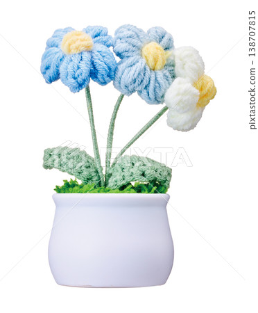 Hand-knitted crochet flowers in a white pot cut out against a white background. Hand-knitted crochet flowers in a white pot cut out against a white background. 138707815