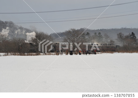 蒸汽機車和馬匹奔跑在白雪皚皚的田野上:北海道冬季旅遊景象。 蒸汽機車和馬匹奔跑在白雪皚皚的田野上:北海道冬季旅遊景象。 138707855