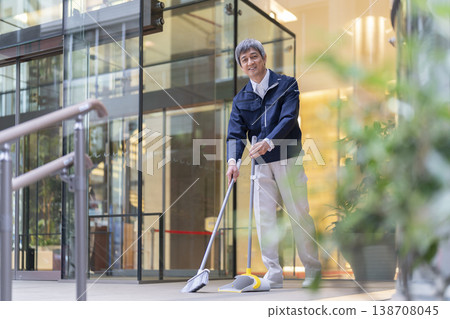 一位資深樓宇維修人員正在清潔樓宇入口,照片中他面帶微笑,看向鏡頭。 一位資深樓宇維修人員正在清潔樓宇入口,照片中他面帶微笑,看向鏡頭。 138708045