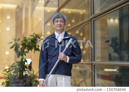 A man in his 60s wearing work clothes and smiling at the camera; apartment building manager/facility staff member (image) A man in his 60s wearing work clothes and smiling at the camera; apartment building manager/facility staff member (image) 138708046