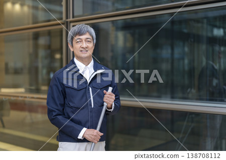 一位六十多歲、穿著工作服、對著鏡頭微笑的男子；公寓大樓管理員/設施工作人員（圖） 138708112