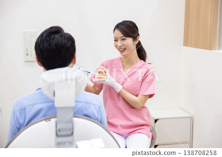 Dentist, dental hygienist providing toothbrushing instruction 138708258